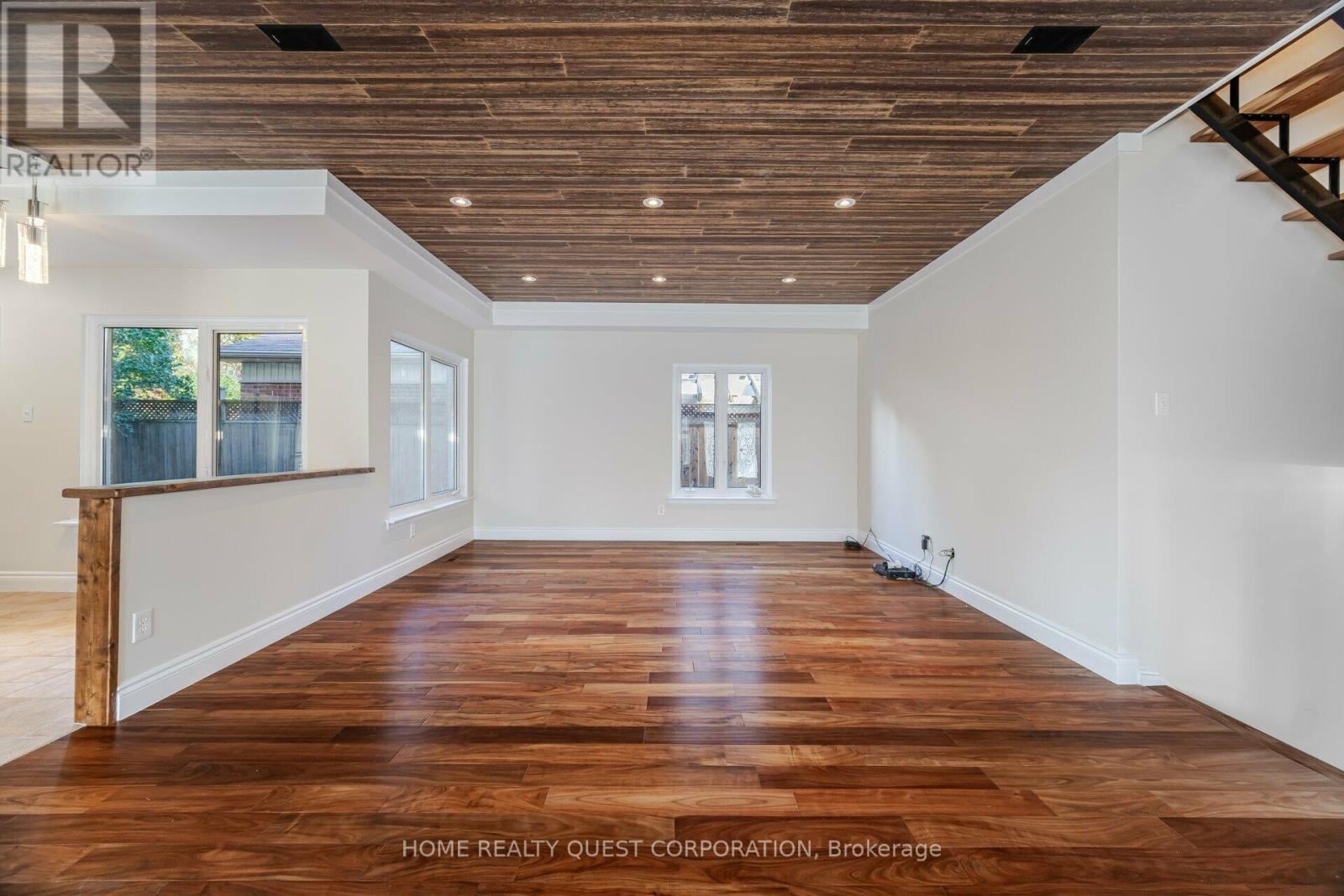 A spacious room with wooden floors and a high ceiling.