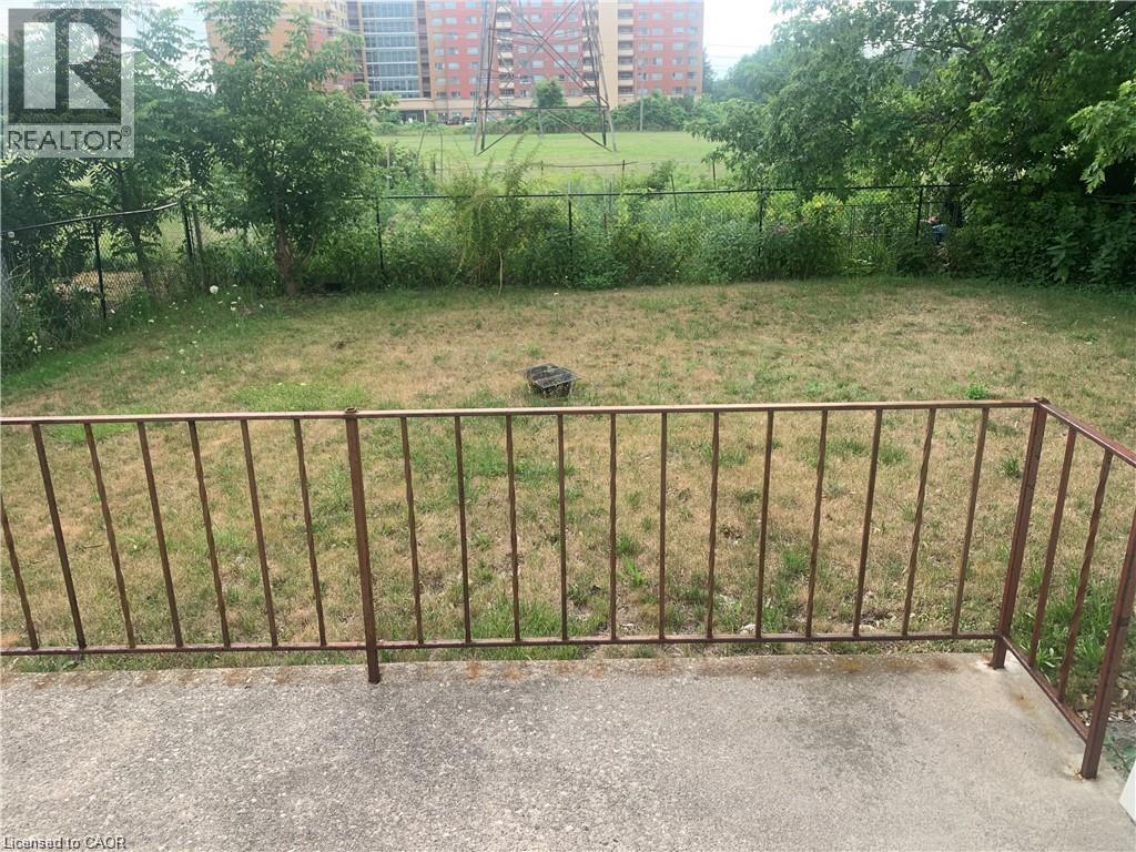 A backyard with a metal fence and a grassy area.