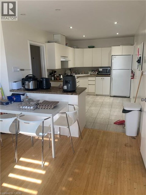 A kitchen with white cabinets and a white fridge.