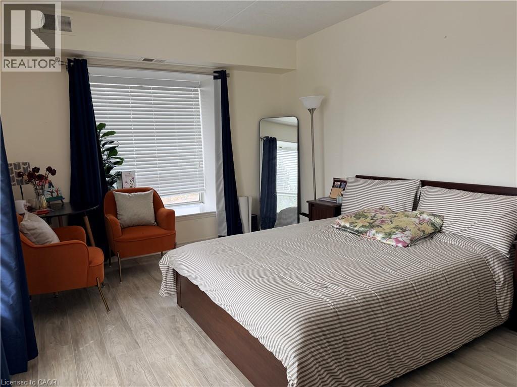 A bedroom with a large bed and a chair with a plant on it.
