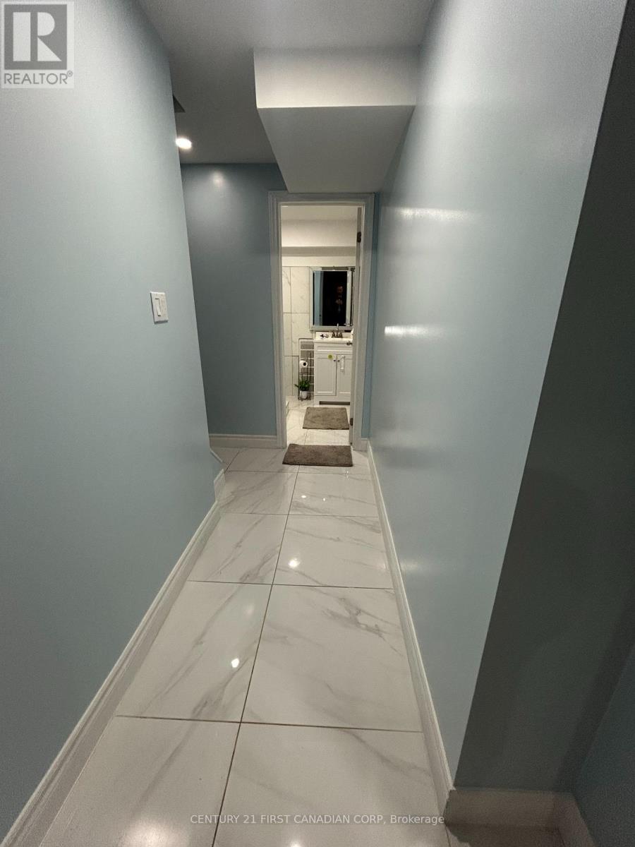 A hallway with a marble floor and a door at the end.
