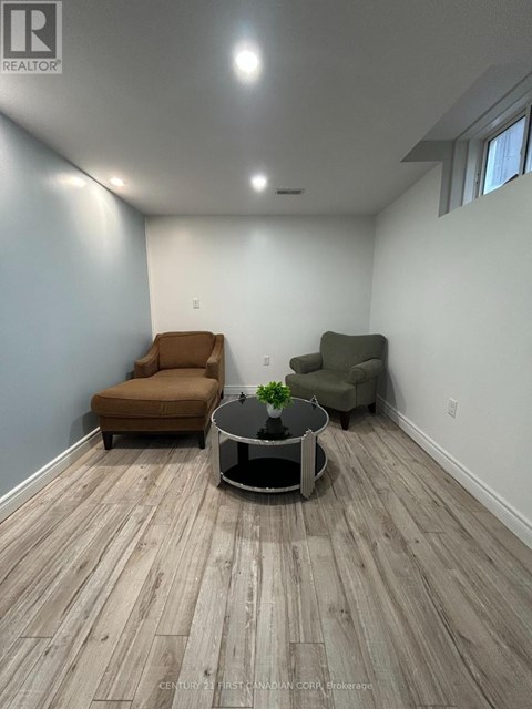 A living room with a brown chair and a green chair with a coffee table in between.