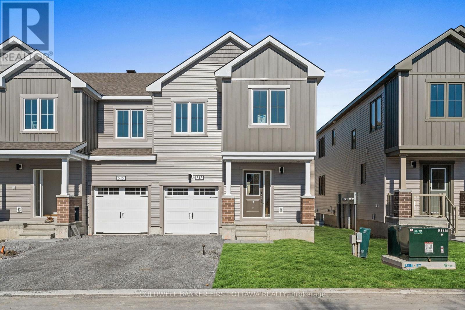 A row of houses with garages and driveways.