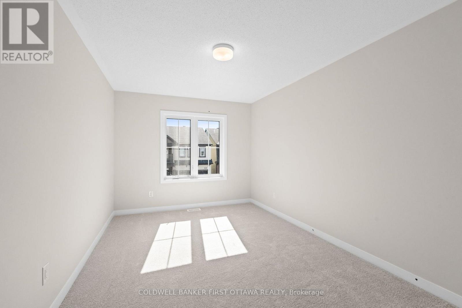 A room with a window and a view of a building outside.