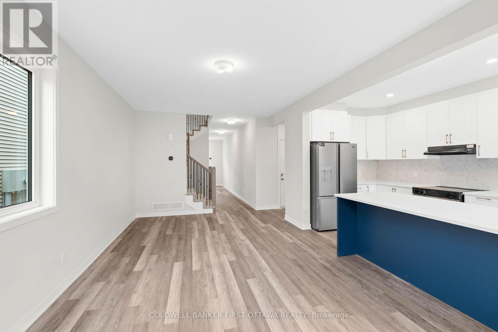 A spacious kitchen with white cabinets and a blue accent wall.