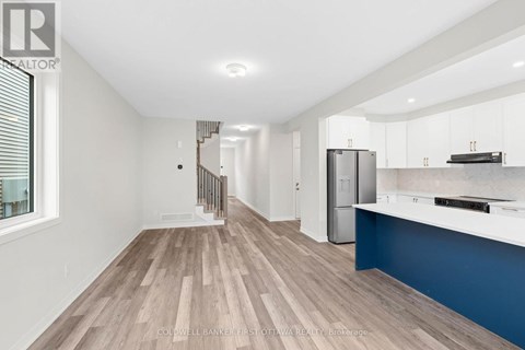 A spacious kitchen with white cabinets and a blue accent wall.