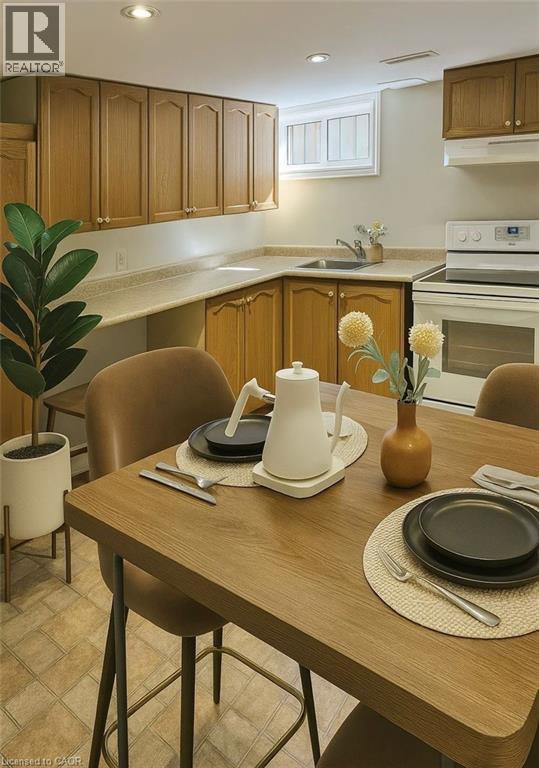 A kitchen with a table set for two with a vase of flowers on it.
