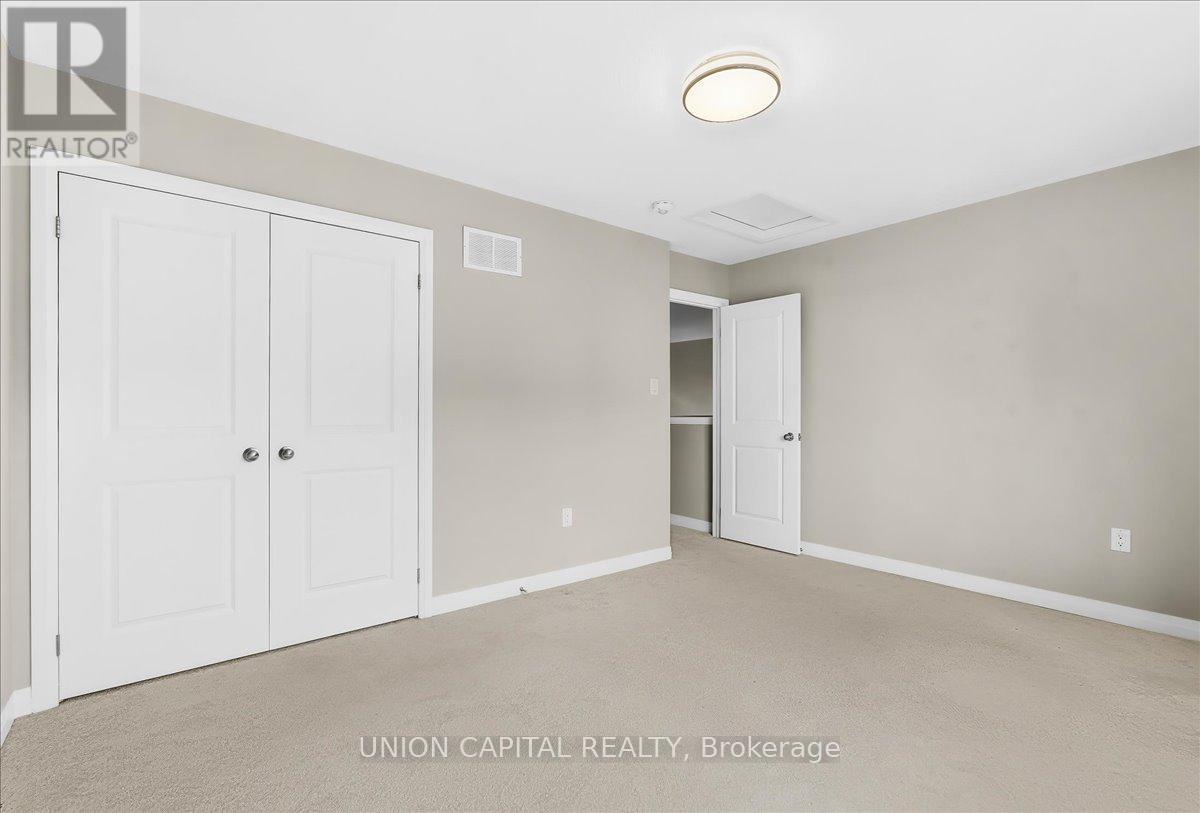 A bedroom with a white closet and carpeted floor.