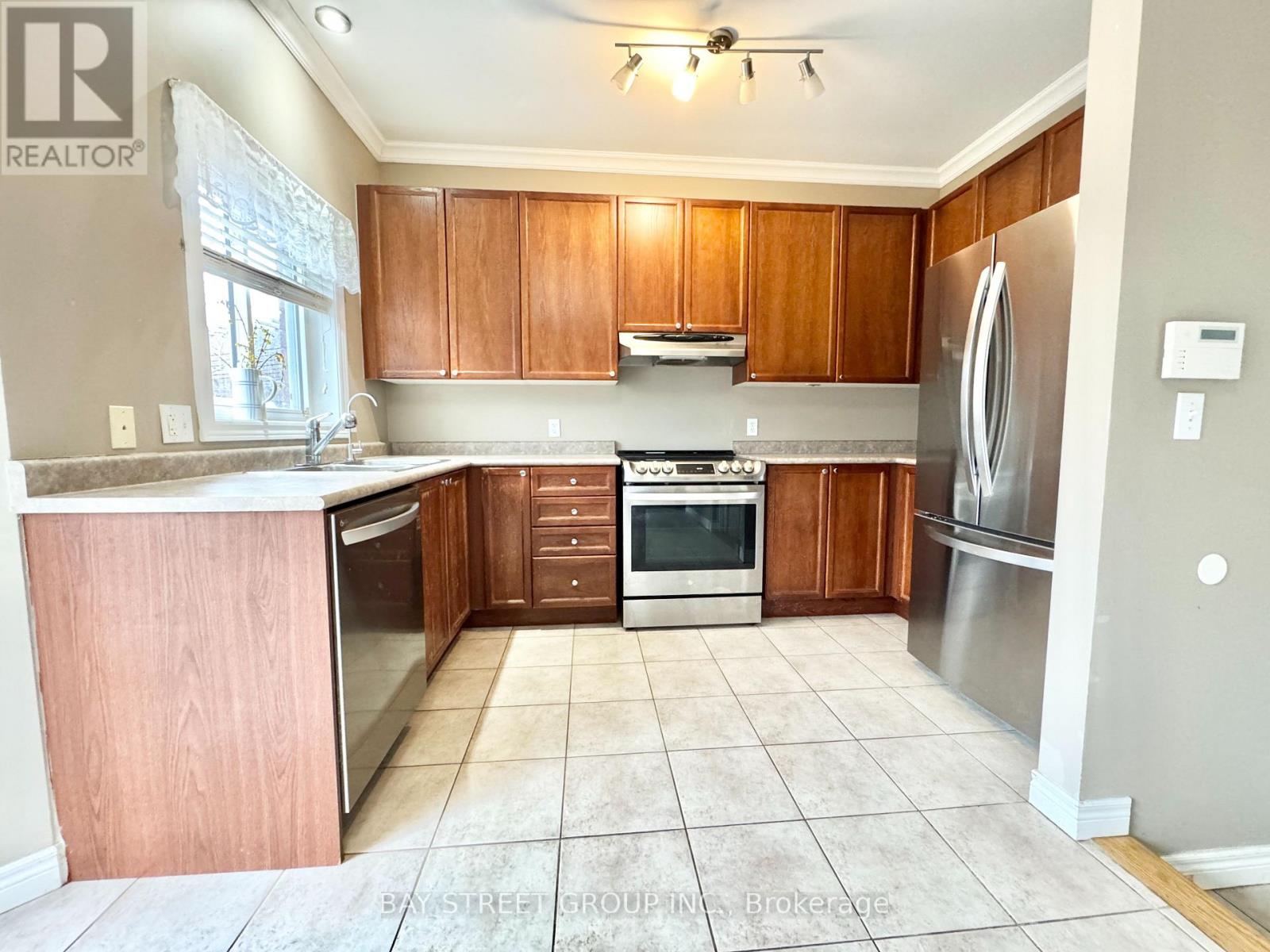A kitchen with wooden cabinets and a tile floor.
