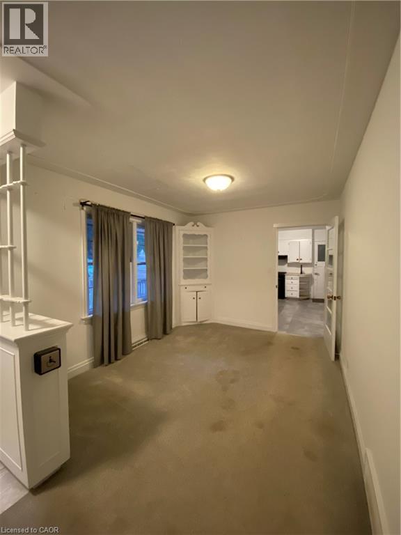 A spacious room with a large window and a radiator on the wall.