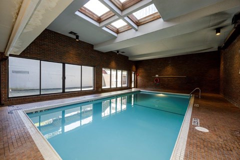 A large indoor swimming pool with a skylight above it.
