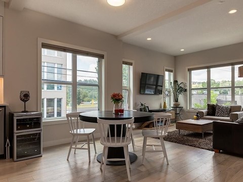 A modern dining room with a black table and white chairs.