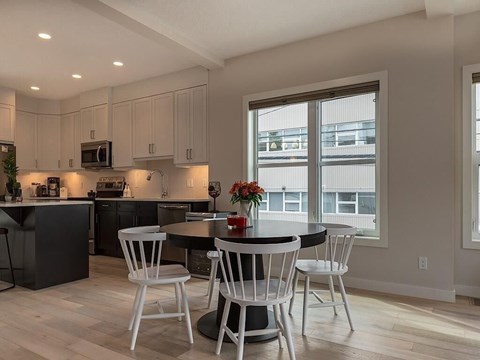 A kitchen with a table and chairs.