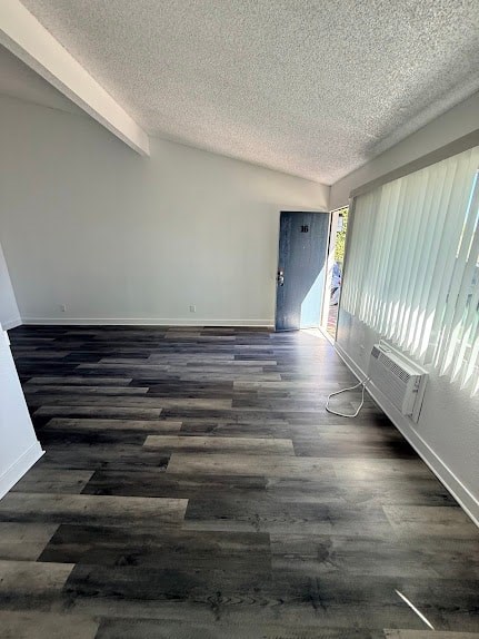 A room with a wooden floor and a door on the right side.
