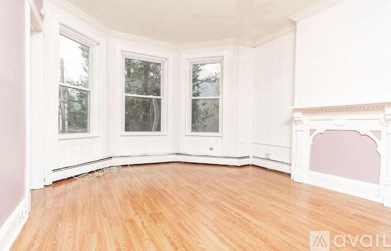 A room with a fireplace and wood flooring.
