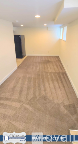 A room with a carpeted floor and a door on the left side.