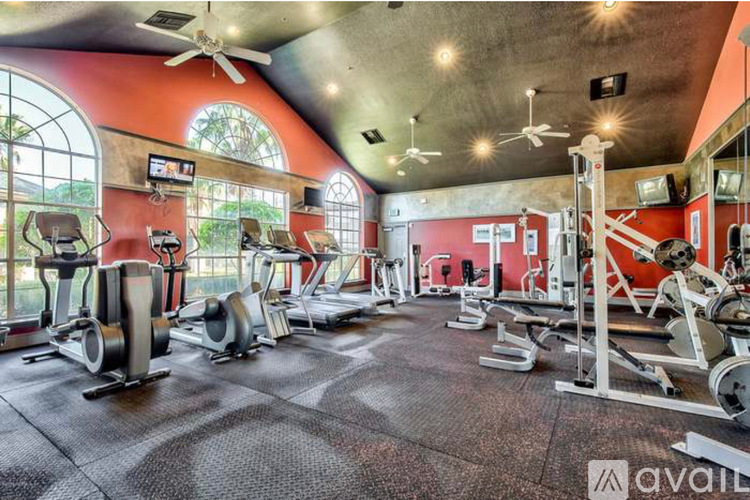 A gym with a variety of equipment including treadmills, weights, and exercise machines.
