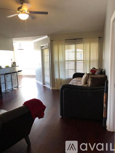 A living room with a couch and a fan.