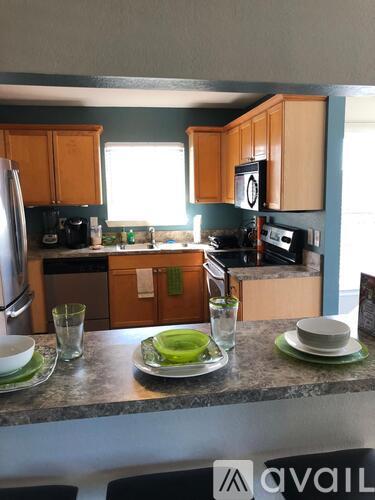 A kitchen with a table set for two with green plates.