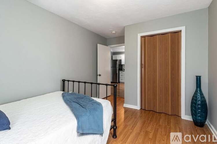 A bedroom with a white bed and a blue pillow.