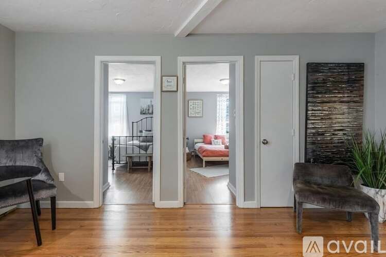 A living room with a grey chair and a wooden floor.