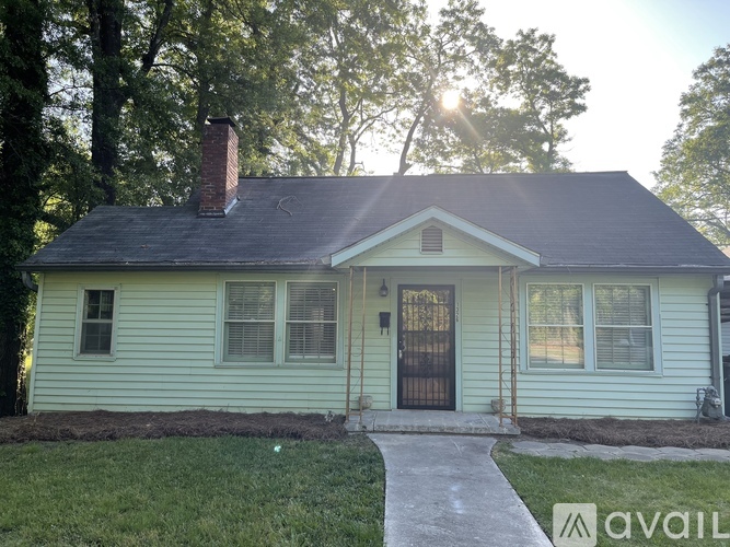 A house with a green siding and a black door is available for purchase.