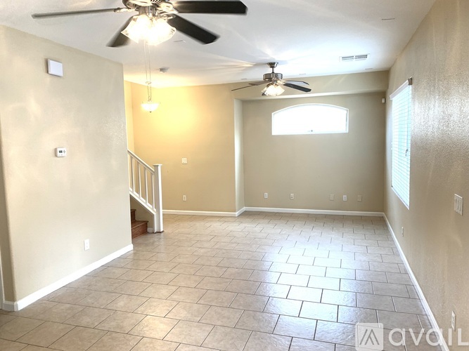 A room with a ceiling fan and tiled floor.