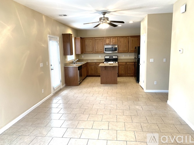 A kitchen with a fan and tile flooring.