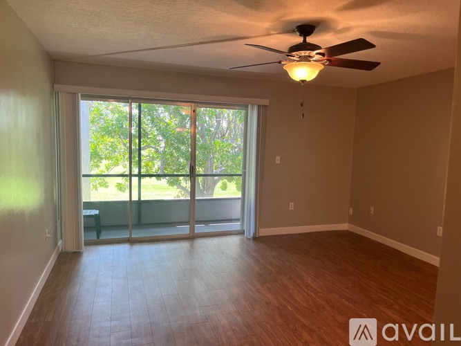 A room with a ceiling fan and sliding glass doors leading to a patio.