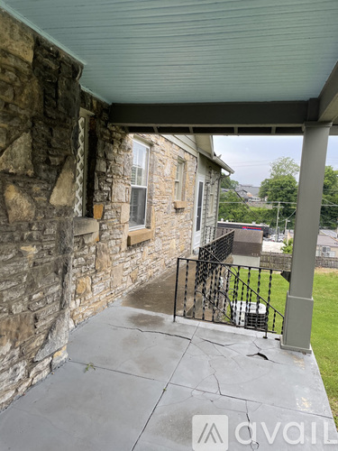 A stone building with a metal railing and a metal pole.