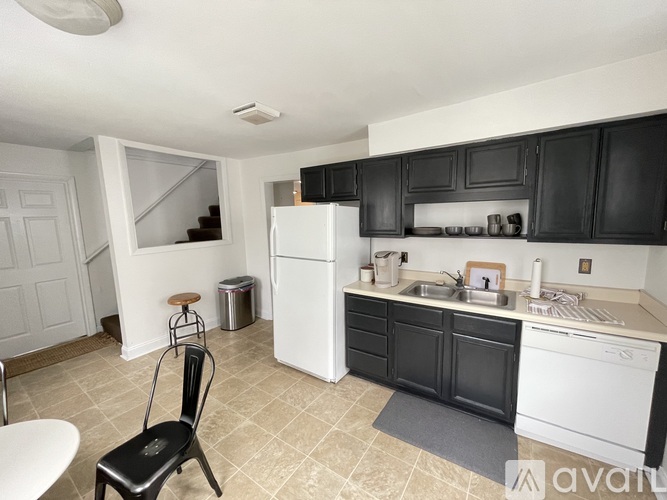 A kitchen with black cabinets and white appliances.