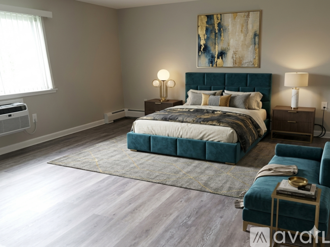 A bedroom with a large bed and a painting on the wall.