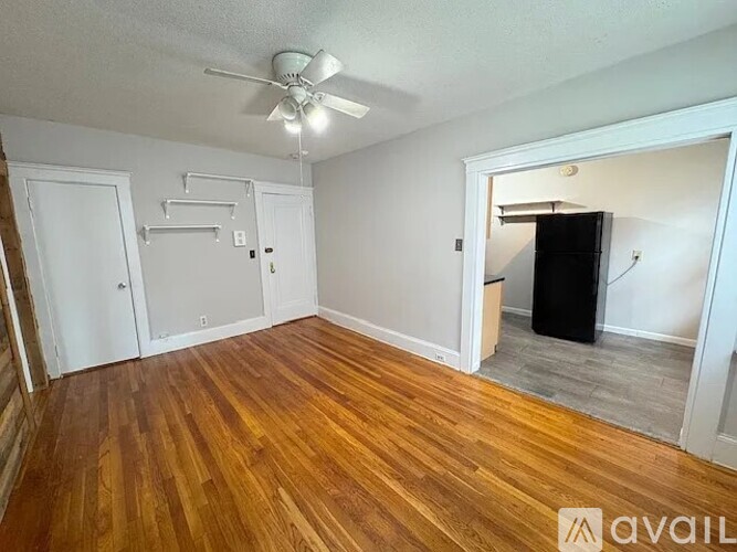 A room with wooden floors and a ceiling fan.