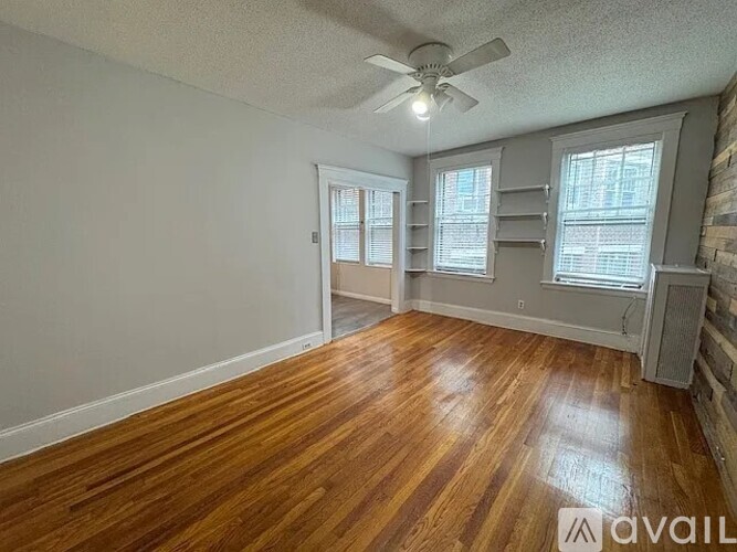 A room with wooden floors and a ceiling fan.