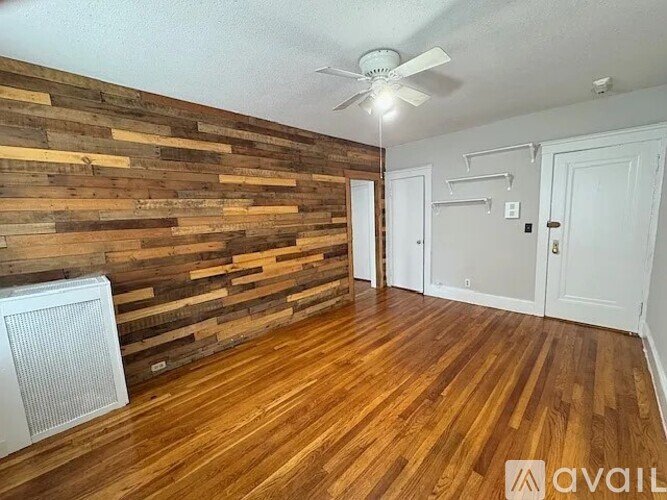 A room with wooden floors and a wall made of wooden planks.