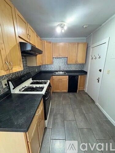 A kitchen with wooden cabinets and a black countertop.