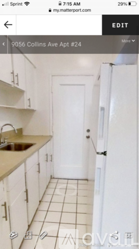 A white door is in the middle of a white kitchen.