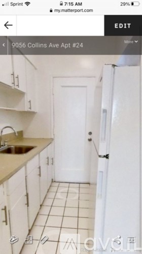 A white door is in the middle of a white kitchen.