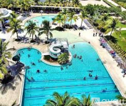 A large swimming pool surrounded by palm trees.