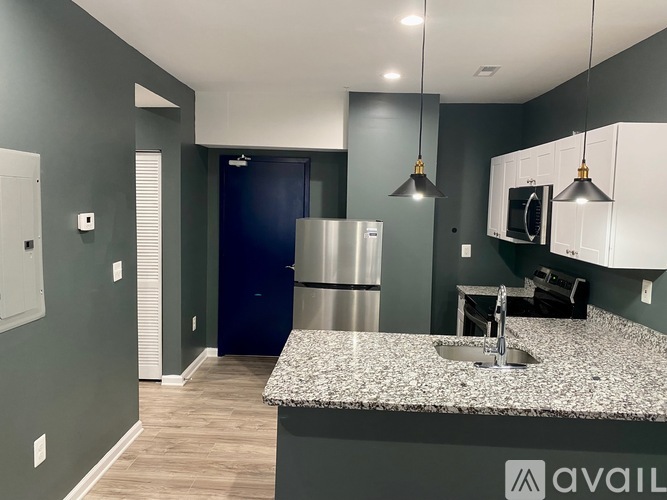 A kitchen with a granite countertop and stainless steel appliances.