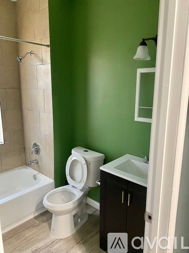 A white toilet sits in a bathroom with green walls.