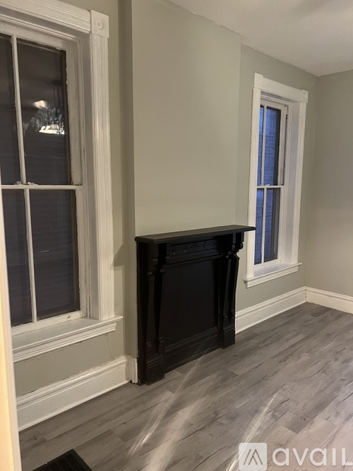 A room with a black fireplace and a window.