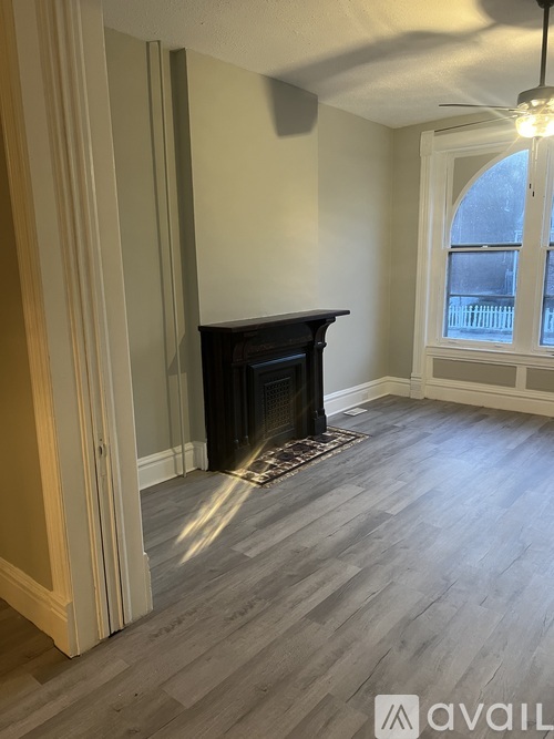 A room with a fireplace and a window.