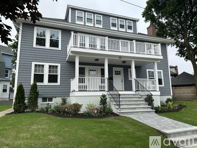 A two-story house with a front porch and a white door.