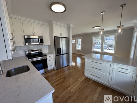 A kitchen with white cabinets and a marble countertop.