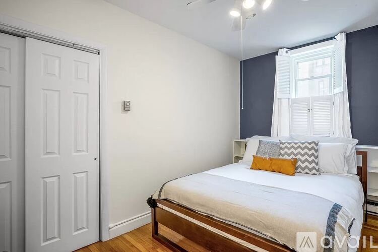 A bedroom with a white bed and a white door.