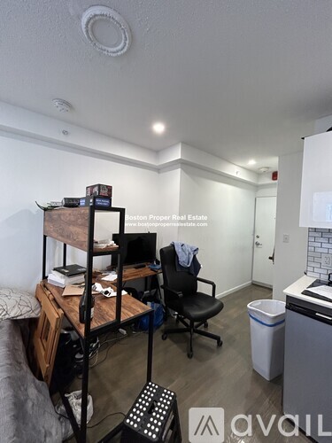 A room with a bed, desk, and chair.