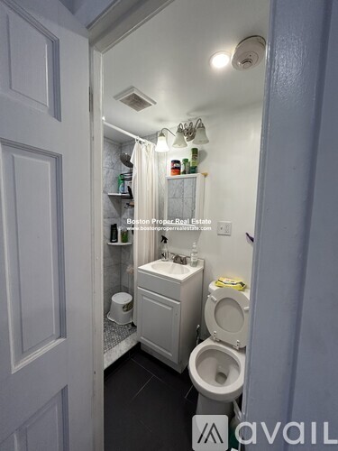 A bathroom with a toilet, sink, and mirror.