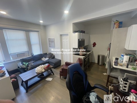 A living room with a couch, chair, and a dining table.