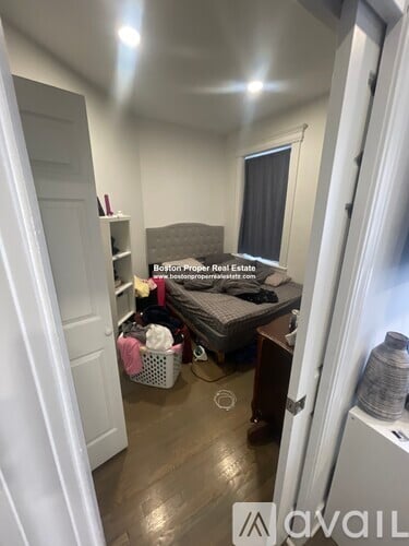 A room with a bed, a desk, and a window.